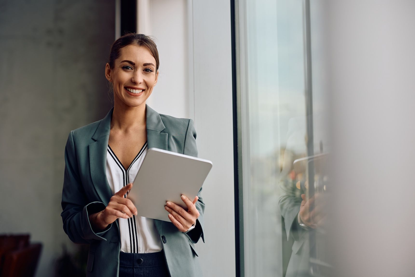 Busy professional woman holding a tablet while dressed sharp.
