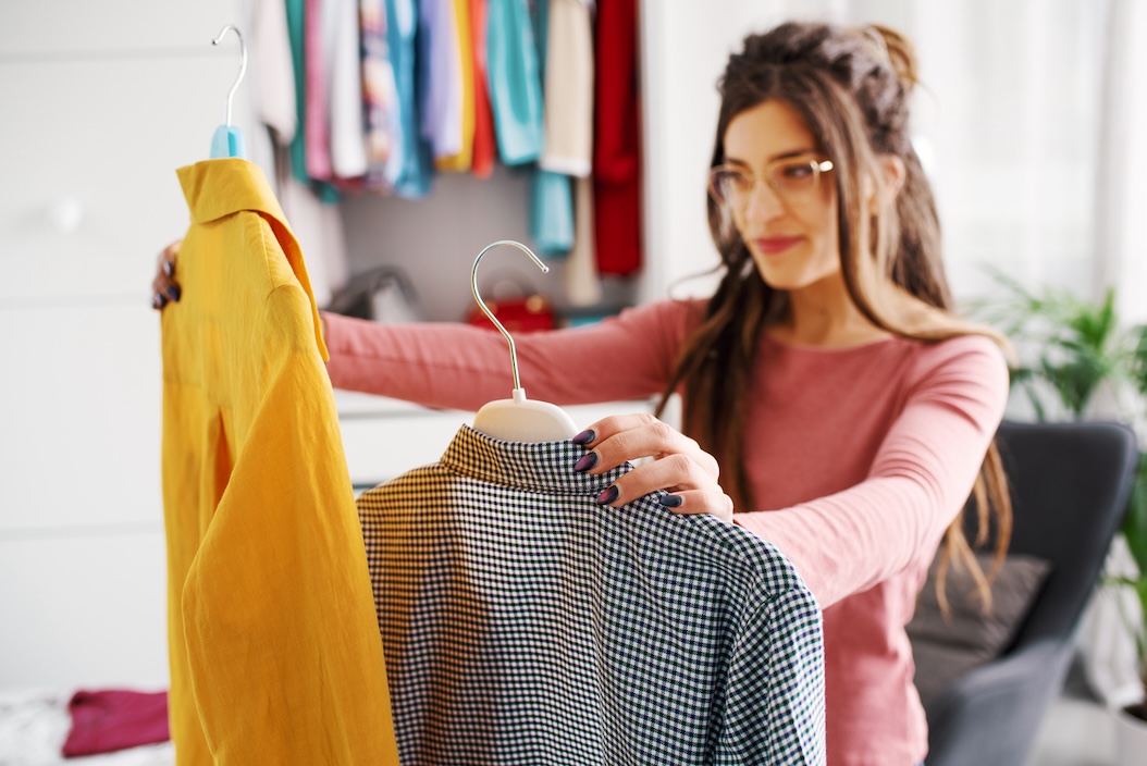 Happy woman holding her fresh clean clothes from laundry delivery.