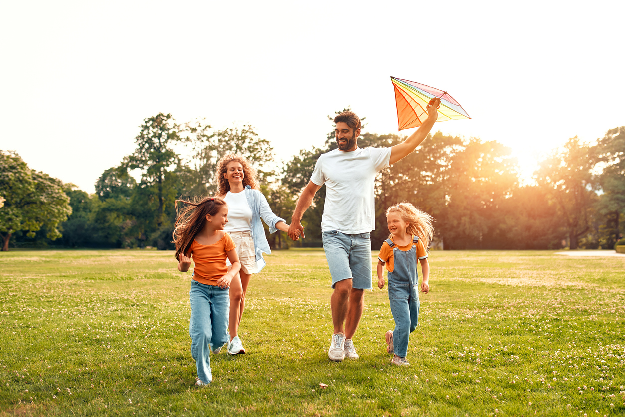 Family flying a kite outside enjoying free time instead of doing laundry in Nashville TN